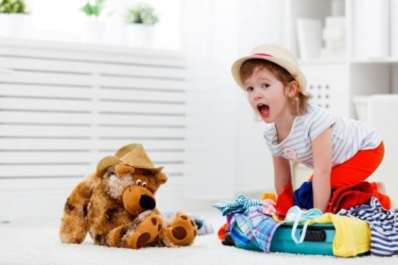 Petote fille qui fait sa valise pour partir en vacances